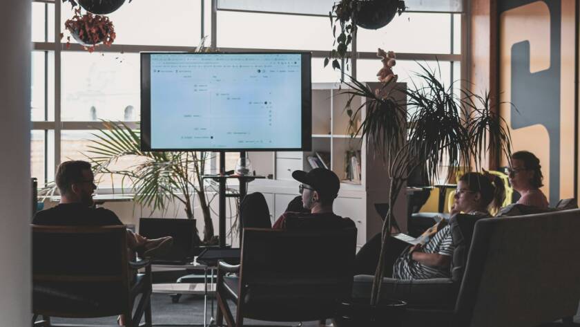 man in black shirt sitting on chair in front of computer monitor