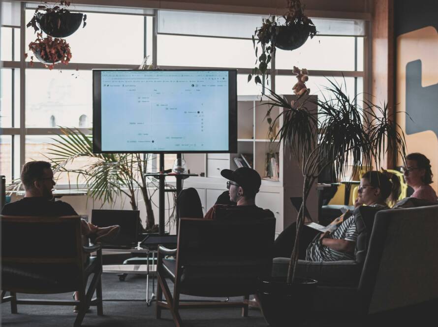 man in black shirt sitting on chair in front of computer monitor