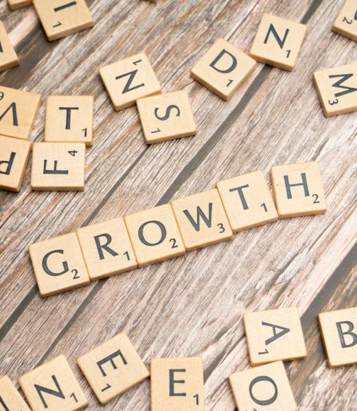 scrabbled letters spelling growth on a wooden surface