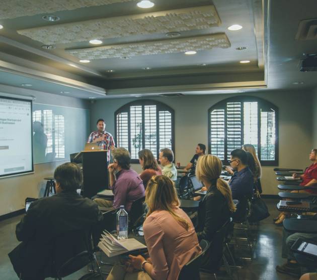 a group of people in a room with a projector screen