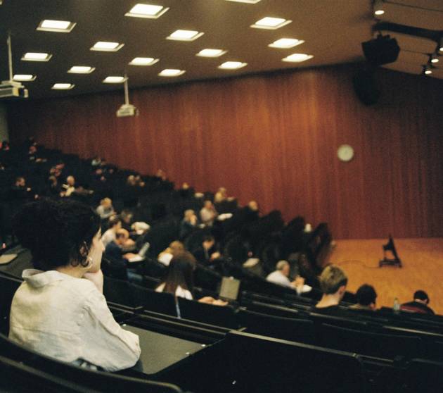 People attend a lecture in a large auditorium.